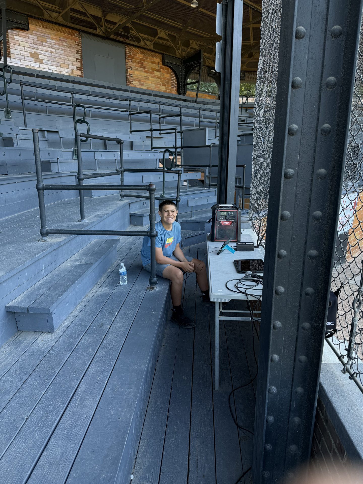 Youth boy playing video game at baseball stadium.
