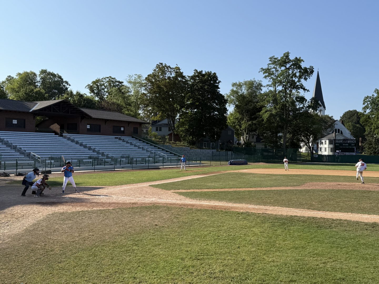 Baseball players in action during a game at a local field.