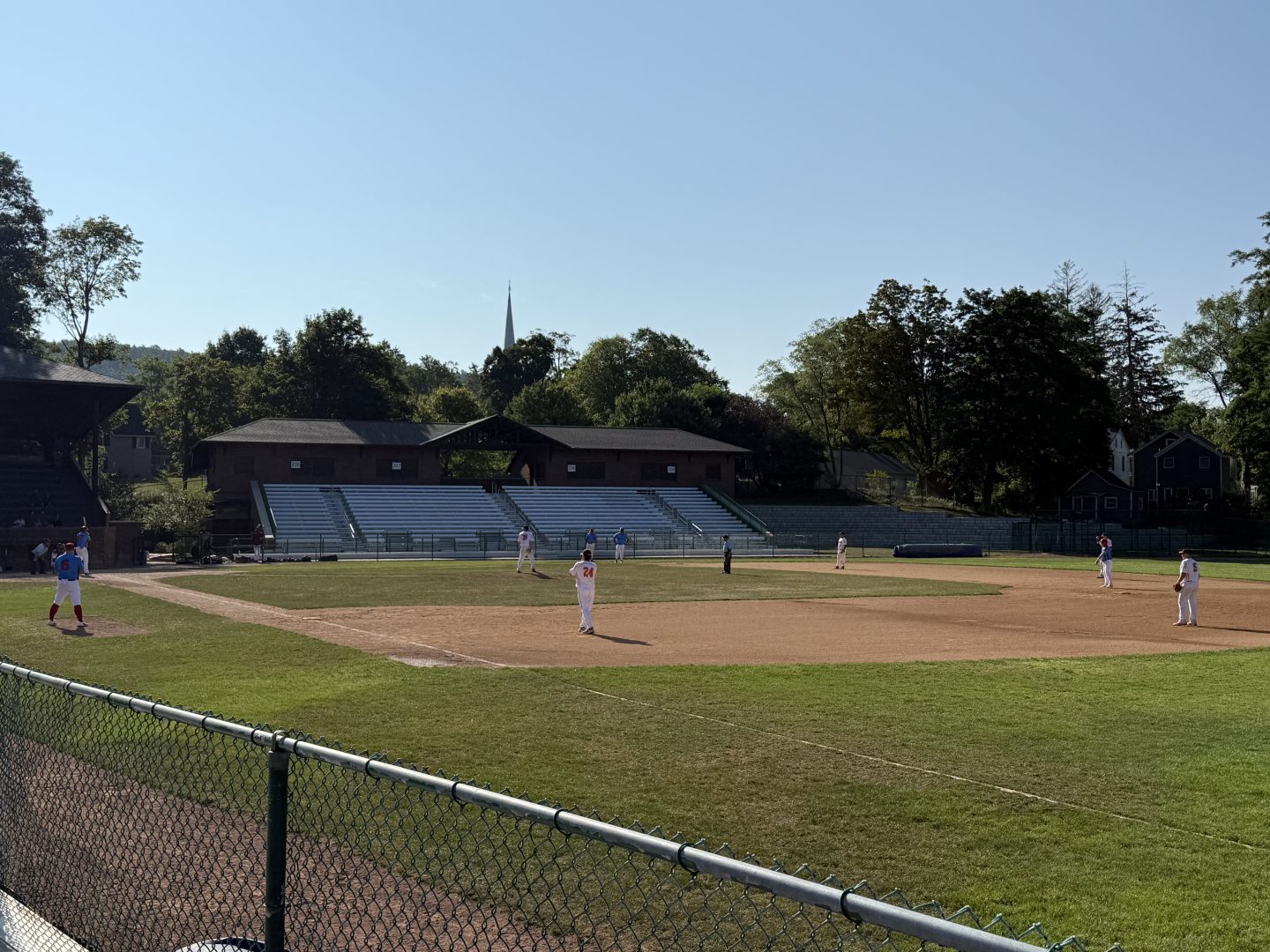 Baseball players warming up on the field during a game.