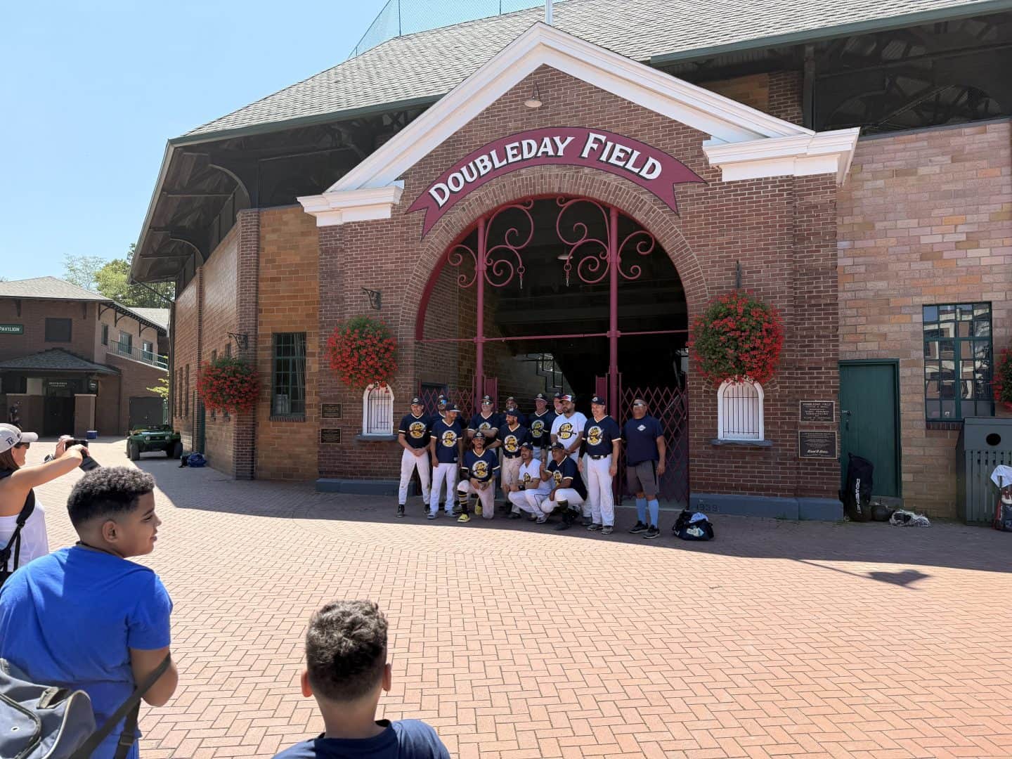Group of women baseball players posing at DoublePlay Field entrance.